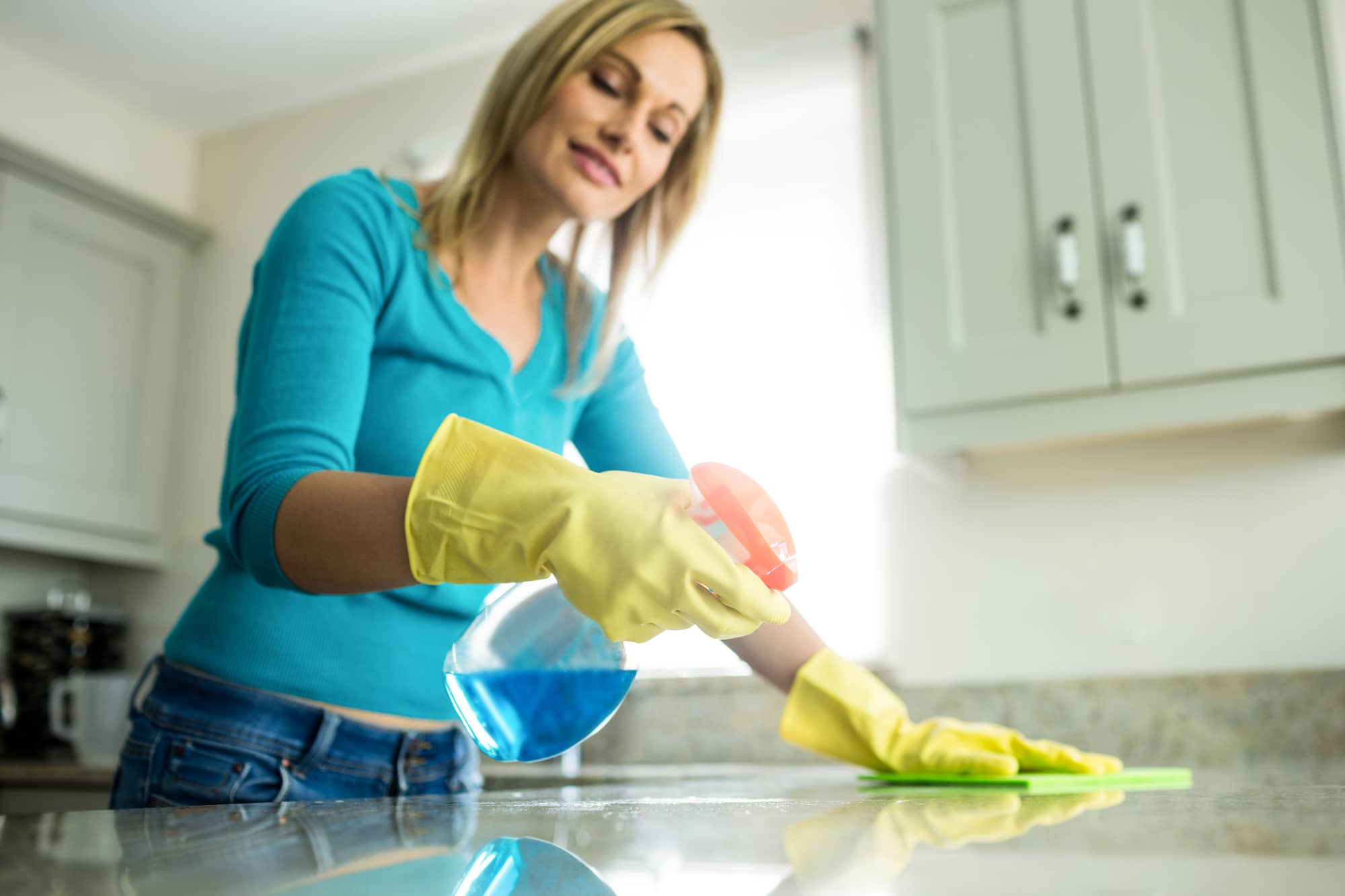 woman demonstrating how to clean granite countertops